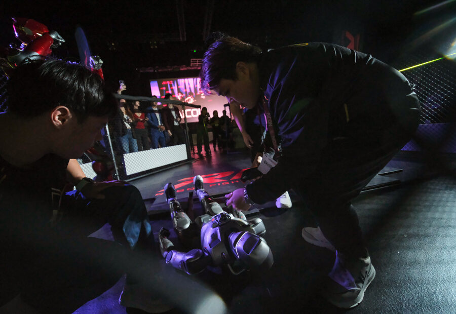 RFC tech team kneeling in the cage to work on a downed robot